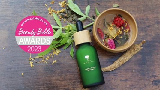 green glass serum bottle. Cup of tea with green tea, flowers, rose, osmanthus, calendula, pomegranate, ginseng